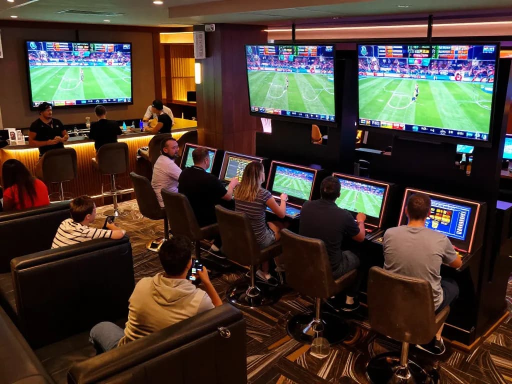 Bsport enthusiasts engaging in live sports betting at a modern casino's vibrant betting area.